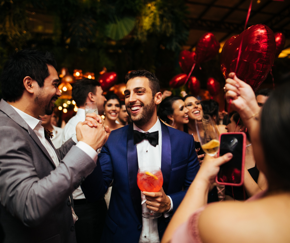 men dancing at wedding reception wearing white button-down shirt, tie, and sport coat